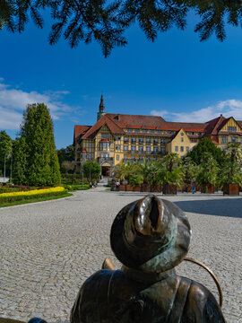 2025-09-09 view of Polonia sanatorium through a bronze monument, Kudowa-Zdroj, Poland