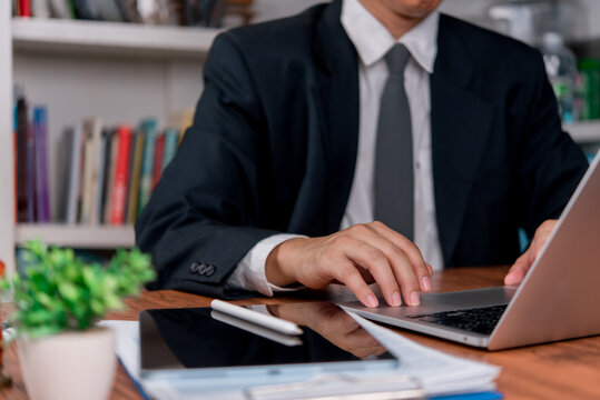 Business person working on laptop with tablet and stylus at office desk for digital workflow productivity and paperless business administration