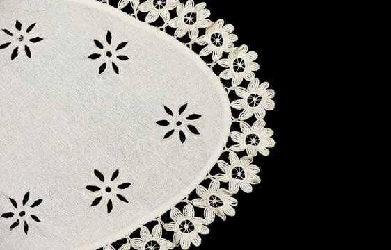 Oval crochet napkin doily lace, antique crocheted Grandma's Doily, detail of bobbin needle lace embroidery, tablecloth, one napkin isolated on black background. Craft vintage linen. Flat lay, border