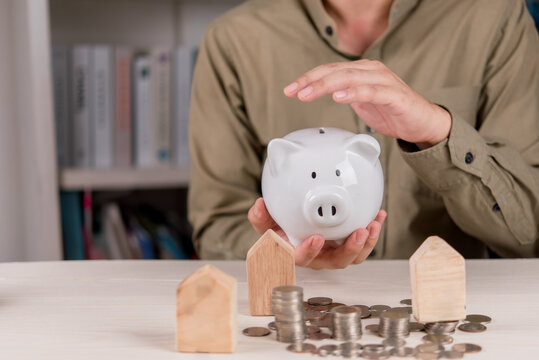 Piggy Bank with Coins and Wooden Houses for Home Savings Mortgage Planning Property Investment Budget and Financial Goals