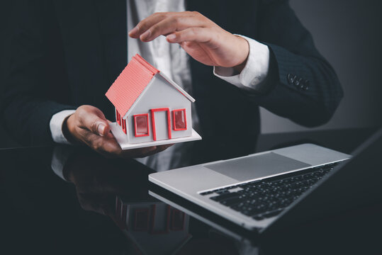 Home Protection Concept with House Model and Laptop for Property Insurance Mortgage Planning Real Estate Finance and Security