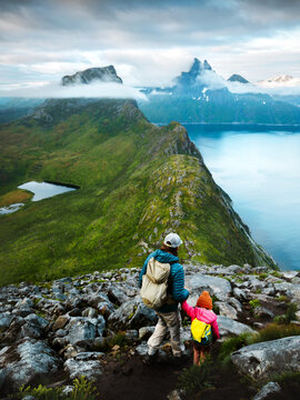 Family travel father and child climbing mountains in Norway active vacations, parent and kid explore hiking trails in Senja together outdoors adventure camping trip eco tourism in the wild