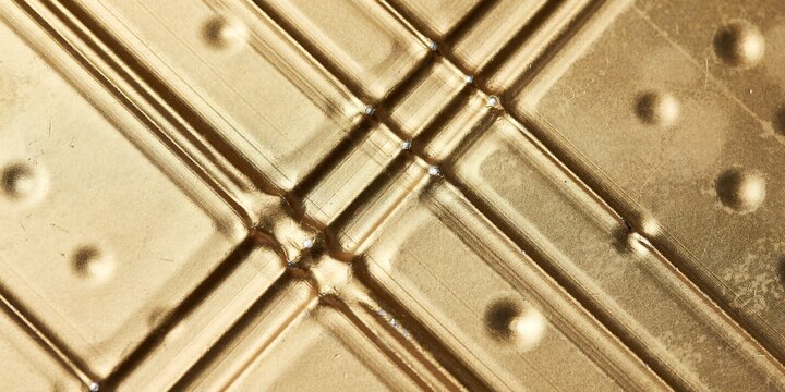 Golden industrial metal texture, embossed brass surface with geometric lines, luxury metallic background for tech and design