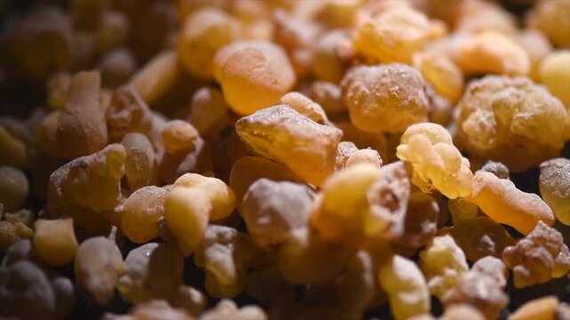 Olibanum Frankincense resin backdrop, Boswellia sacra background. Frankincense or olibanum aromatic resin for incense and perfumes, dark rotating backdrop, design, religion. 
