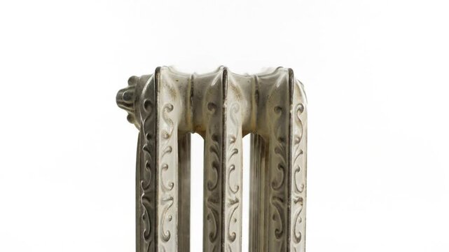 Antique cast iron radiator close up with ornate floral details on bright white background