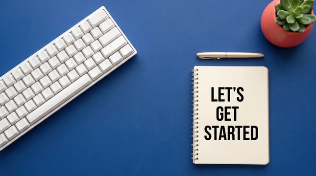 Blue desk workspace with keyboard notebook and pen for productivity and planning