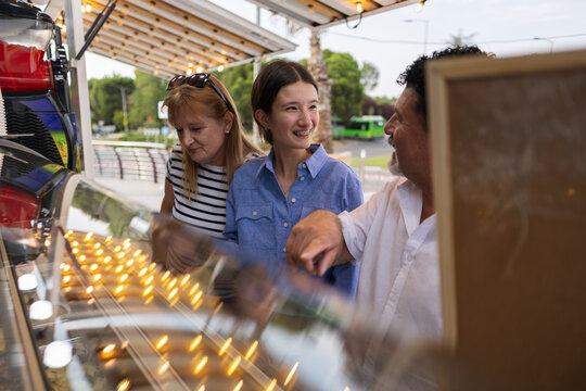 Family enjoying street food selection at evening market stall