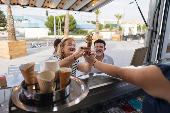 Woman buying ice cream from street vendor enjoying summer