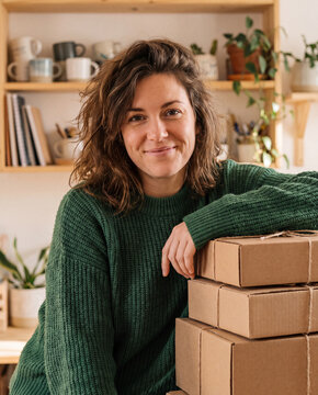 Small business owner standing beside neatly packed parcels