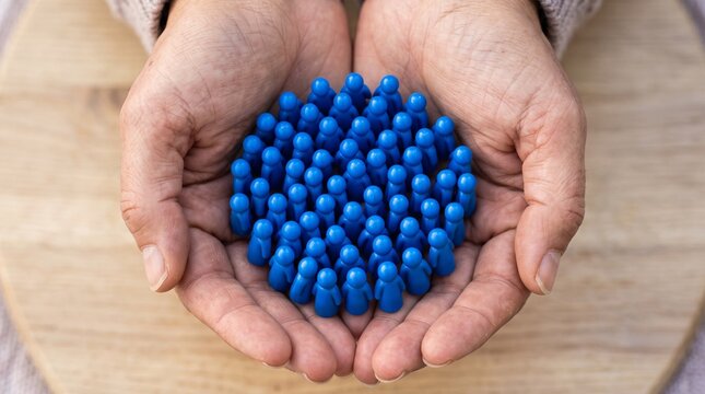 Hands holding a group of blue figurines representing community with hands hold cluster