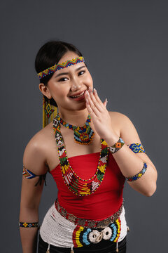 Cheerful Sabahan Woman Wearing Traditional Murut Tahol Simba Costume Covering Mouth