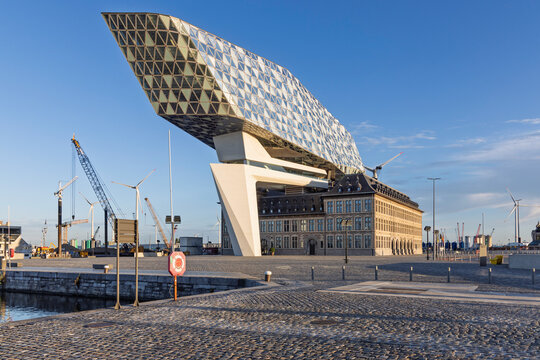 Antwerp, Belgium - 06 September 2026: Clear view of the Port House (Havenhuis) building in Antwerp, showing the contrast between the historical fire station and the modern glass roof.