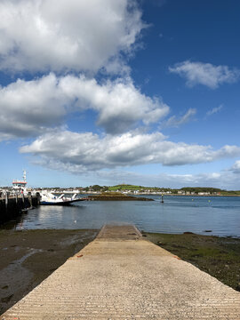 View from the slipway at Strangford across Strangford Lough toward Portaferry, with the vehicle ferry at the terminal beneath a dramatic blue and cloudy sky.
