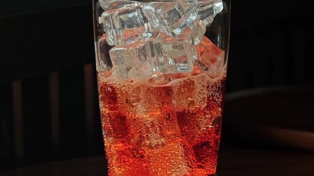 Cola with ice on black background.
