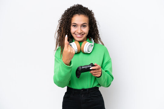 Young Arab woman playing with a video game controller isolated on white background doing coming gesture