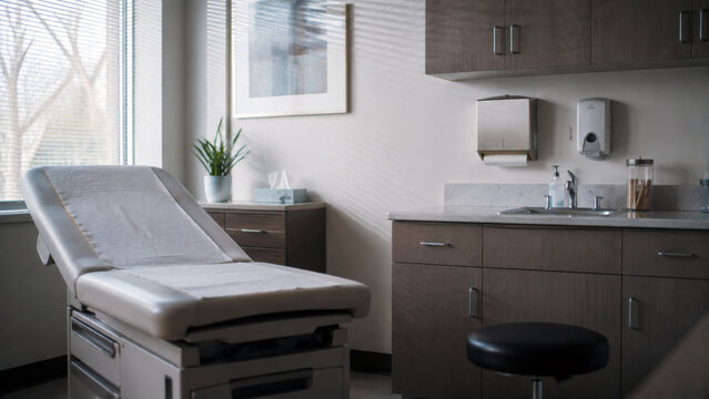 Empty medical examination room with an exam table and clinical equipment, representing healthcare, patient care, checkups and outpatient medical services