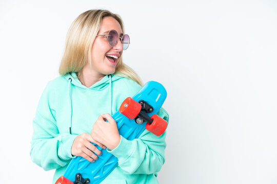 Young caucasian woman isolated on white background with a skate with happy expression