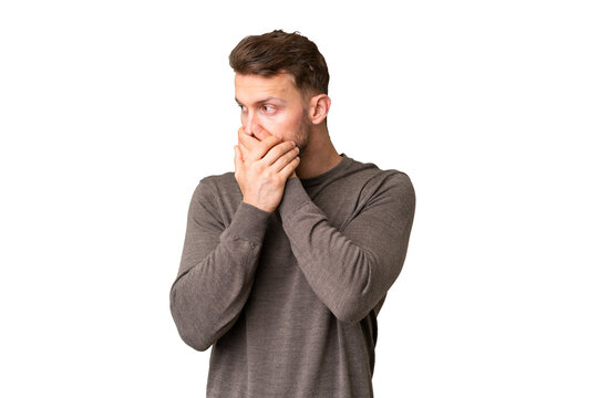 Young handsome caucasian man over isolated chroma key background covering mouth and looking to the side