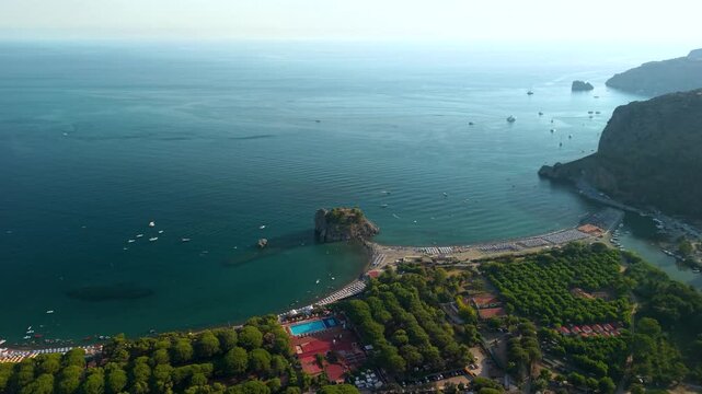 Capo Palinuro Cilento Italy 4K drone video. Sunset cinematic paning footage of Scoglio Mingardo rock revealing twin coves and boats on beach. Scenic coastal travel b-roll stock video