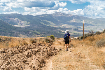 Fototapeta premium Lone hiker walking on a hot summer day. 