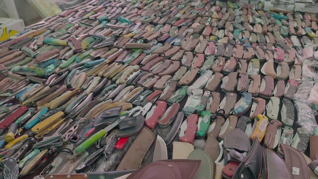 Numerous Automatic Switchblade Knives Displayed on Market Counter