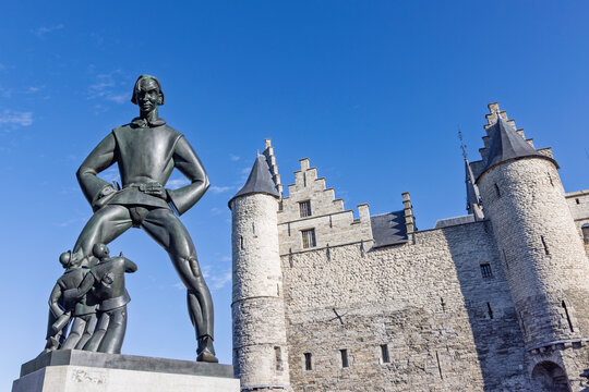 Antwerp, Belgium: Close up view of the legendary Lange Wapper bronze statue and the medieval stone architecture of the Het Steen fortress.