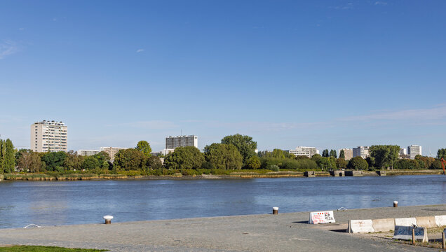 Antwerp, Belgium: View across the Scheldt river towards the green riverbank and residential high-rise buildings of the Linkeroever district.