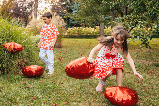 Children Play in the Garden During Summer, Carrying Red Hearts as They Enjoy a Holiday Together
