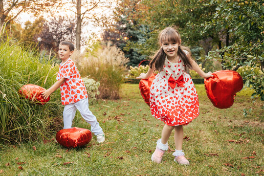 Children Play in a Garden Wearing Heart-Themed Clothes During Summer Holidays, Celebrating Love and Joy on Valentine's Day