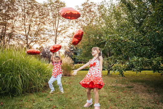 Children Celebrate Summer With Heart-Shaped Pillows in a Garden During a Sunny Holiday