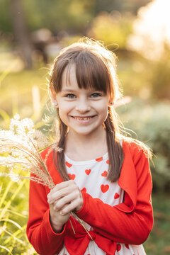 Two Children Enjoying a Summer Day While Collecting Flowers and Expressing Joy and Love With a Heart Theme