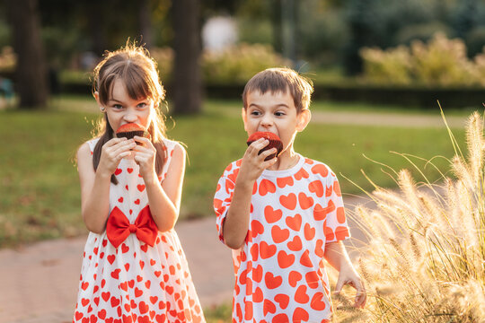 Children Enjoy Cupcakes in a Park During Summer Break, Celebrating Love and Friendship on a Warm Day