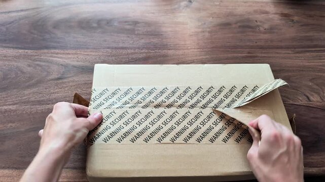 Opening cardboard box on a wooden table. Lifestyle video. Unboxing and delivery concept