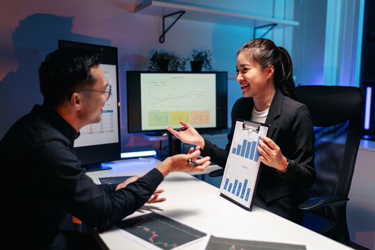 Business professionals analyzing stock market data at night in a