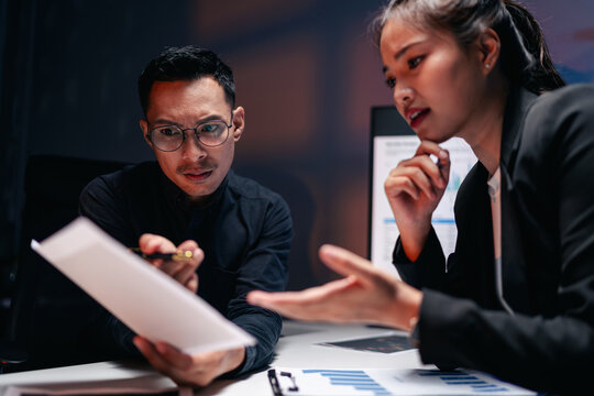Dedicated business professionals analyzing financial data late a