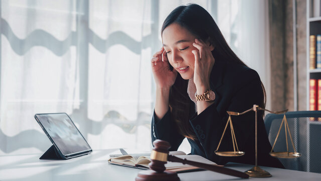 Stressed Asian Woman Lawyer with Headache at Office Desk Gavel S