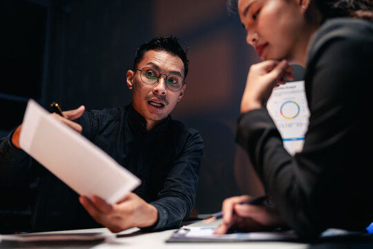Dedicated Adult Professionals Analyzing Business Data During Lat