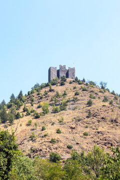 Stone towers of Maglic fortress rising above the hilltop trees