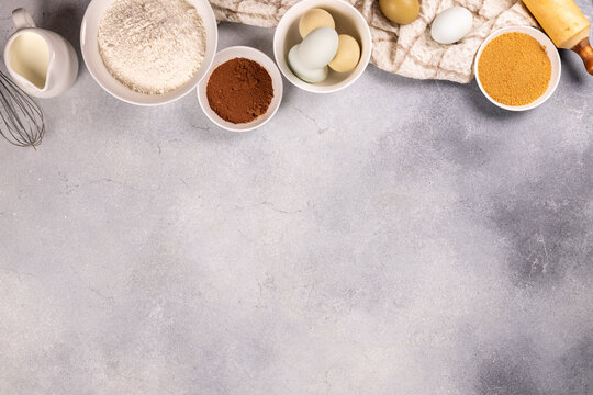 Baking ingredients for homemade pastry preparation on concrete background