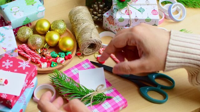 Woman preparing christmas gift wrapping on a wooden table