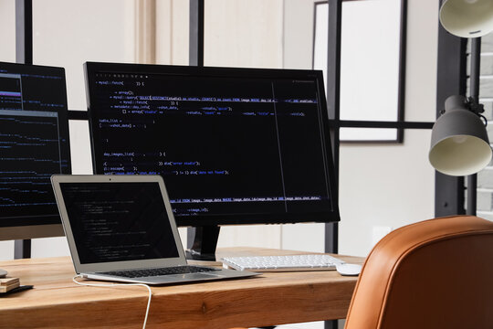 Programmers workplace with gadgets near folding screen in office
