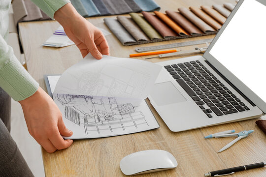 Female interior designer with drawings at table in office