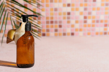Giant Achatina snail and bottle of cosmetic product on beige table near pink tile wall, closeup © Pixel-Shot