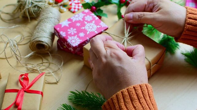 Woman's hands decorating christmas gift box