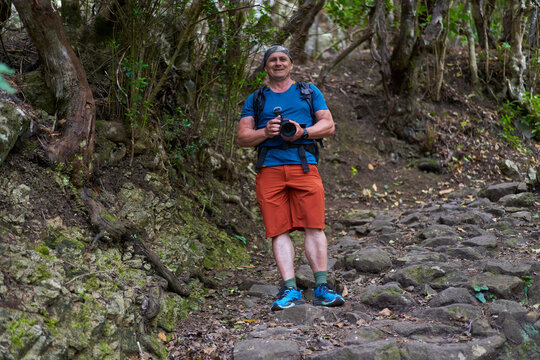 Smiling hiker on rocky forest trai