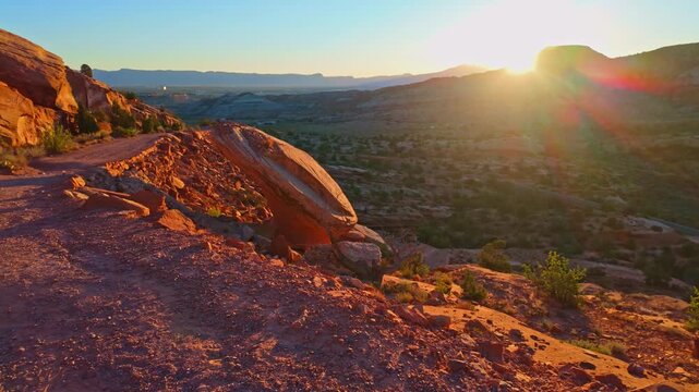 Dawn sunlight illuminates the winding historic switchbacks and red rock canyon vistas along Serpents Trail in Colorado