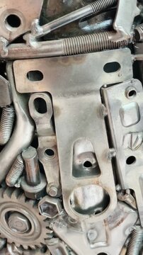 tight oblique overhead closeup of interconnected metal undercarriage hardware with threaded rods, welded joints