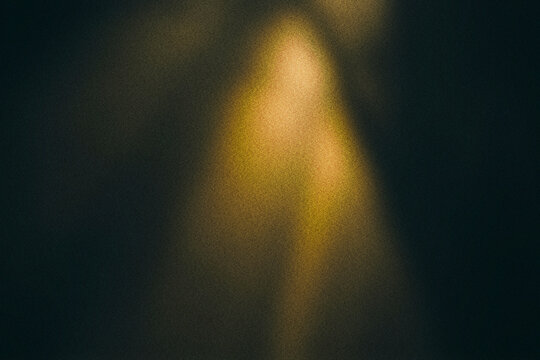 Cinematic golden light leak on dark grainy background, vintage film texture with warm glow, abstract amber lens flare for overlay and backdrop