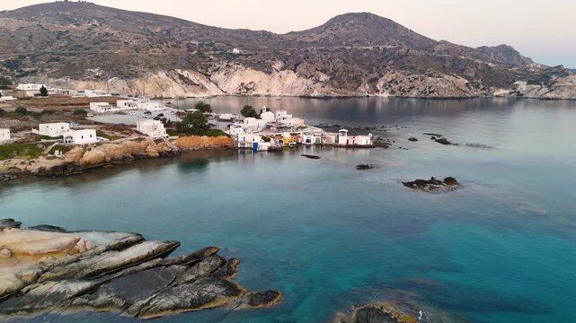 Drone flying over the Greek island Milos toward the village Mandrakia over the azure blue Aegean sea in Greece. 