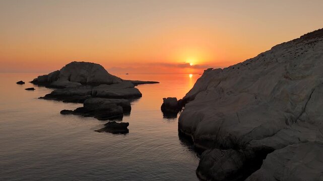 Beautiful orange and red sky in the early morning before sunrise on the Greek island Milos in Greece. 